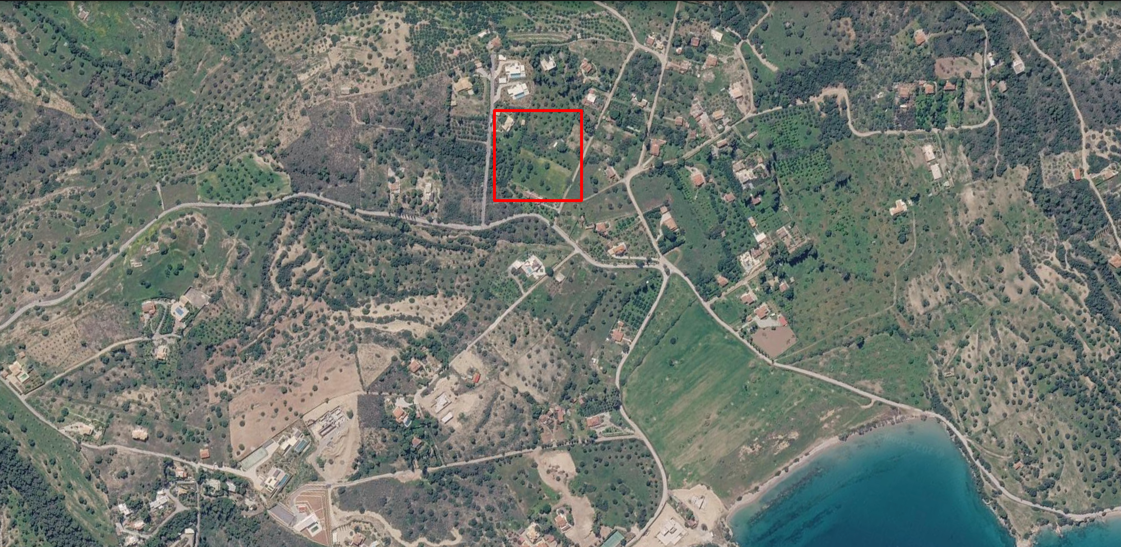 Aerial of a waterfront land parcel above a cove, plot outlined